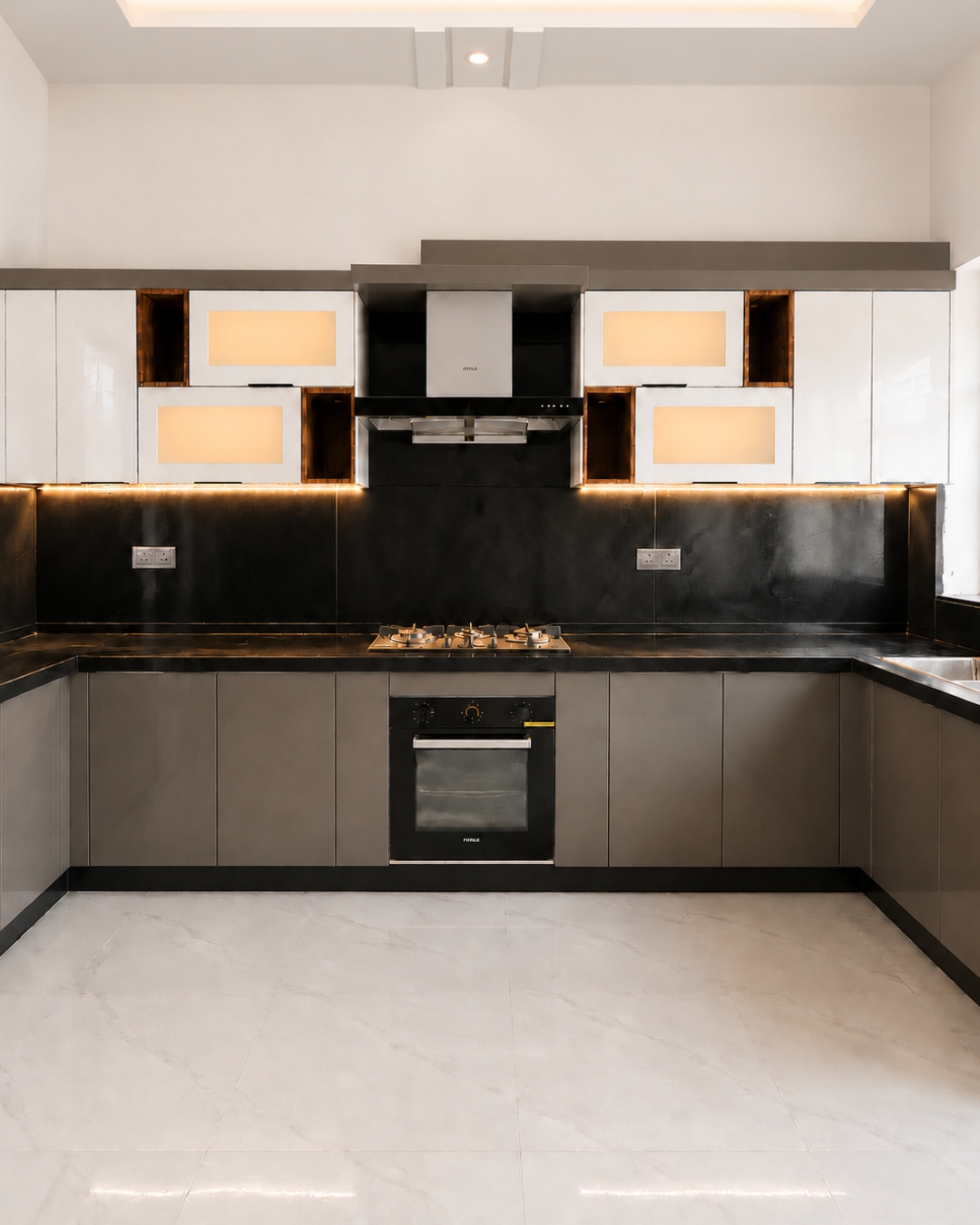1 Pearl white and grey kitchen with glossy cabinets, black countertops and backsplash, warm under cabinet lighting, a gas hob and built in oven.