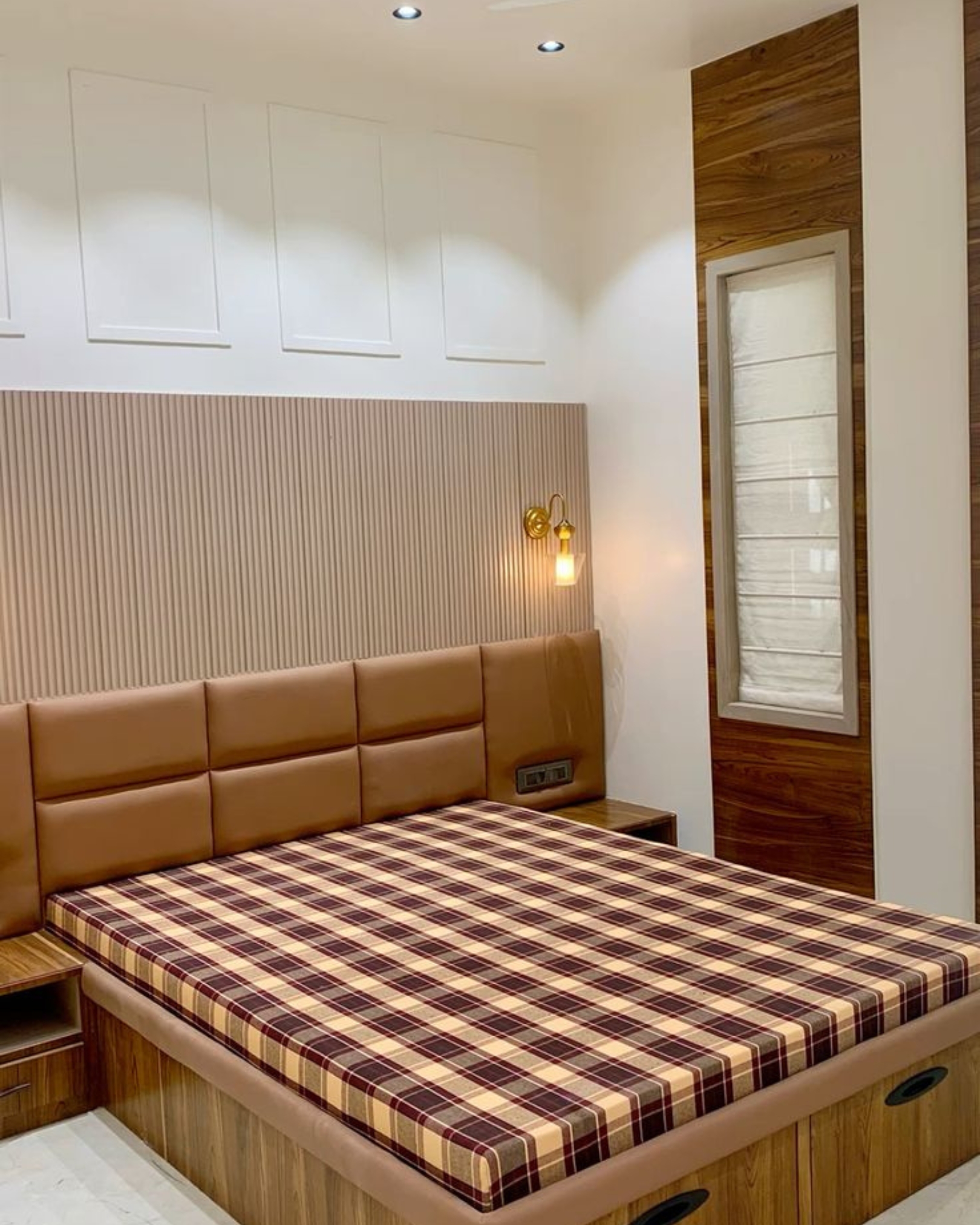 3 Bedroom with a tan padded headboard, wood-look storage bed, cream fluted wall panels and a checked mattress.