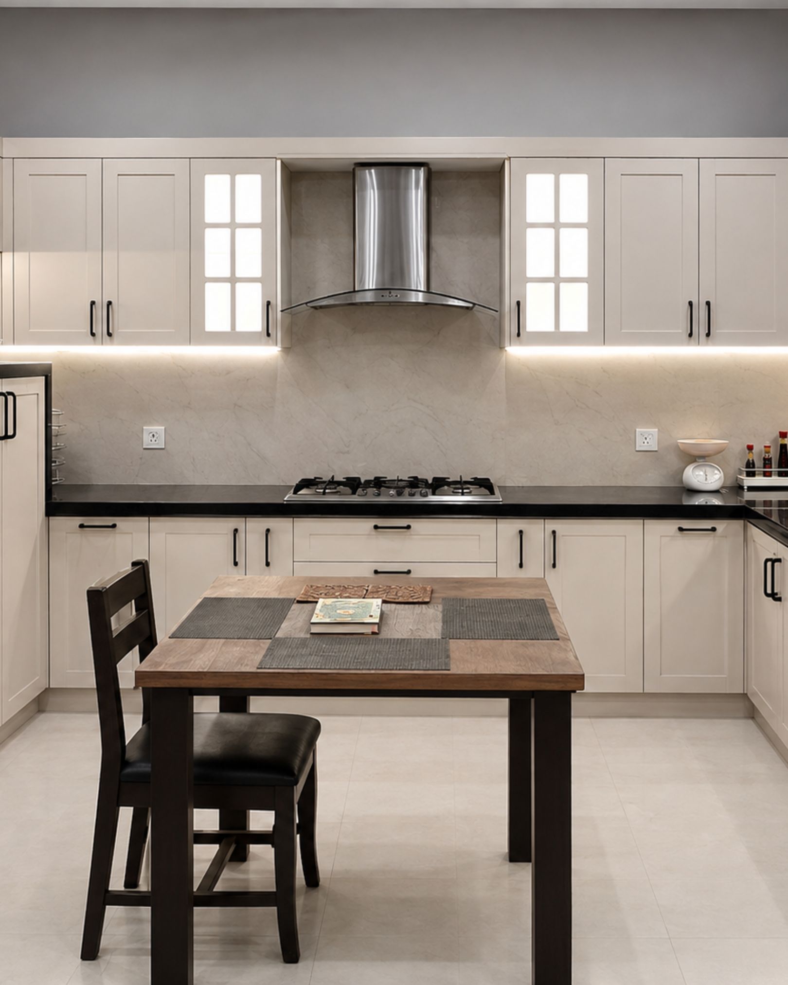 white shaker style cabinet kitchen with under cabinet lighting, silver chimney and center table