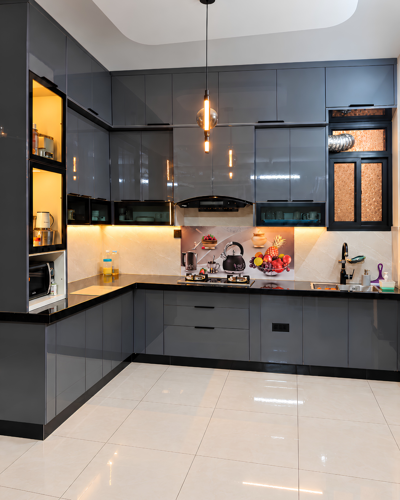 L-shaped kitchen with glossy graphite cabinets, black countertops, illuminated glass displays and warm pendant lighting.