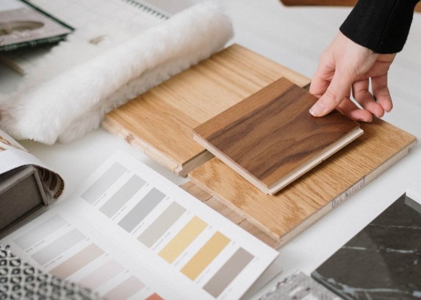 Hands selecting and comparing textile and wood samples for interior design Hands selecting and comparing textile and wood samples for interior design