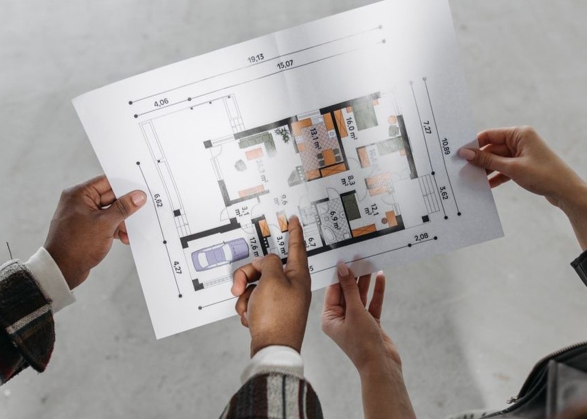 Reviewing architectural plans and measuring new design. Reviewing architectural plans and measuring new design
